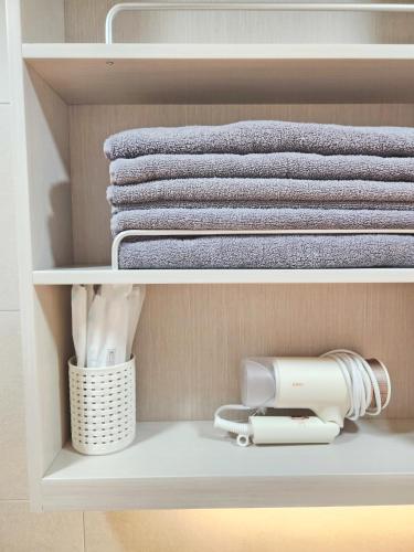 a closet with towels and a hairdryer at Check in Seoul in Hongdae 2 in Seoul