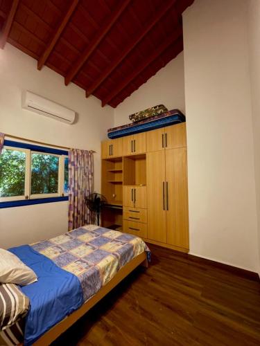 a bedroom with a bed and a wooden cabinet at Casa de Campo Las Marías in Areguá