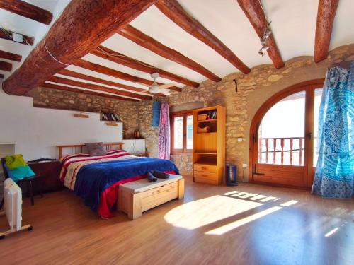 a bedroom with a bed and a stone wall at Amplia Casa en Vinaixa, calle Mayor, Cal Mitger in Viñaixa
