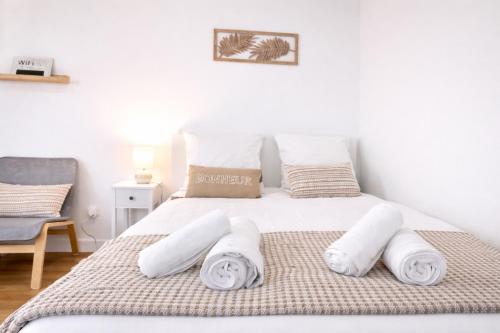 a bedroom with a white bed with towels on it at 5 Mins to Train Station - Paris & DisneyLand - Cosy des Reves Villiers in Villiers-sur-Marne