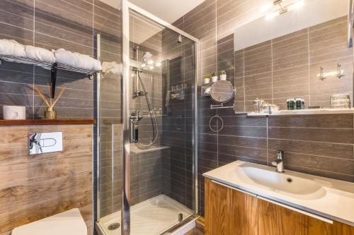 a bathroom with a shower and a sink at Hôtel Le Caillebotis in Cap-Ferret