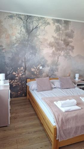 a bedroom with a large bed with a painting on the wall at Blueberry in Buczkowice