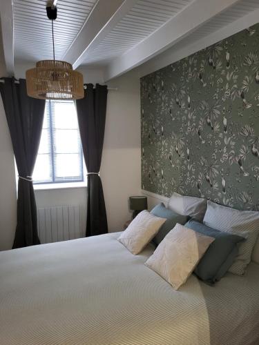a bedroom with a large bed and a window at Les 3 Nuances in Saint-Suliac