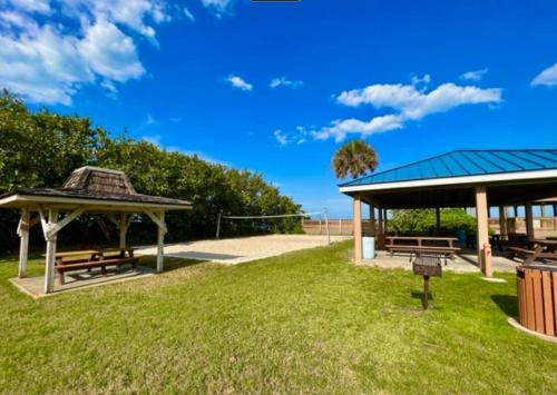 a picnic area with benches and a gazebo at Ocean 21 - Waves & Wonders in Indian Harbour Beach