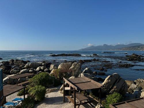 a beach with two picnic tables and the ocean at Departamentos Océano in Maitencillo