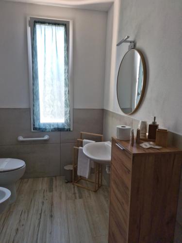 a bathroom with a sink and a toilet and a mirror at Hibiscus Affittacamere - rooms&more in Stanghella