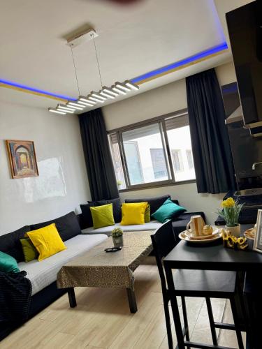 a living room with a couch and a table at Studio pas cher au parc in Mohammedia