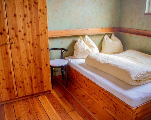 a small room with two beds and a chair at miki Chalets in Pack