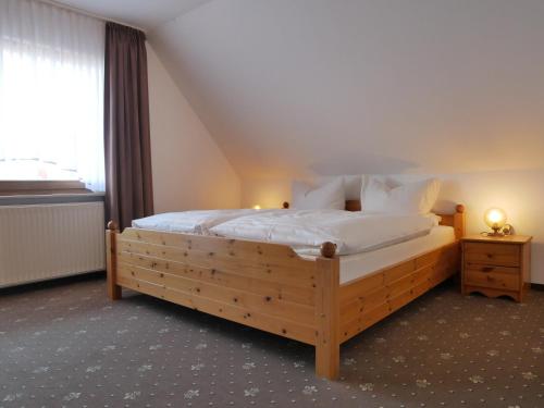 a bedroom with a large wooden bed in a room at Haus Gertrud in Carolinensiel
