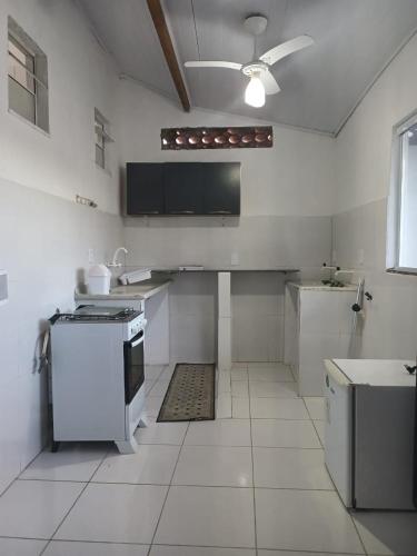 a kitchen with white appliances and a ceiling at Casa inteira 4 pessoas, 2 quartos, suite ar, 2 banheiros, home office, estacionamento, próx praia Itaúna in Saquarema