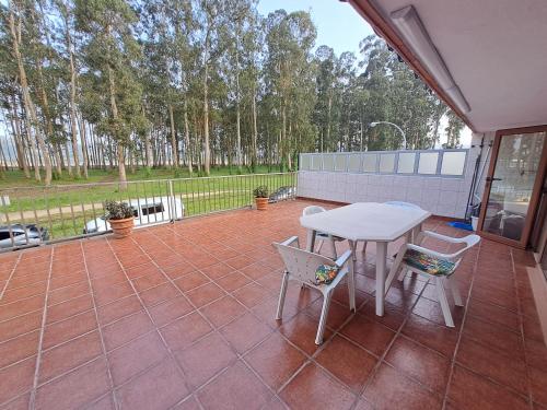 a patio with a white table and two chairs at Nido Ría in Villaviciosa