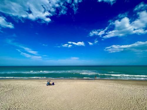 two people standing on a beach near the ocean at Ocean 18 - Oceanside in Indian Harbour Beach