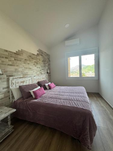 a bedroom with a large bed with pink pillows at El niu del volcà in Olot