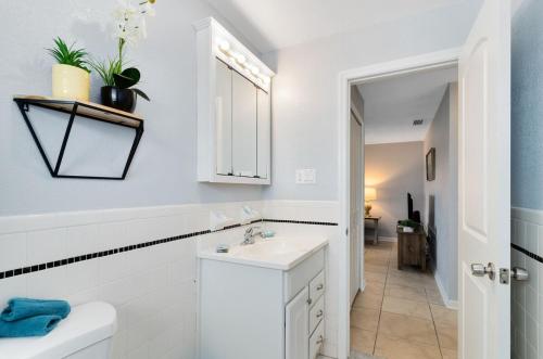 a white bathroom with a sink and a toilet at Ocean 16 - Pier View in Indian Harbour Beach