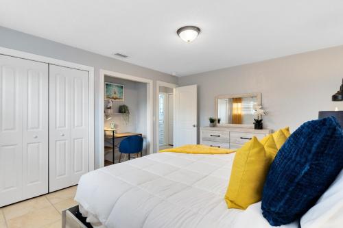 a bedroom with a large white bed with yellow pillows at Ocean 16 - Pier View in Indian Harbour Beach
