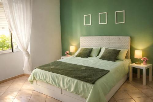 a bedroom with a bed with a green wall at Rosemary s House Napoli Vomero Private Parking in Naples