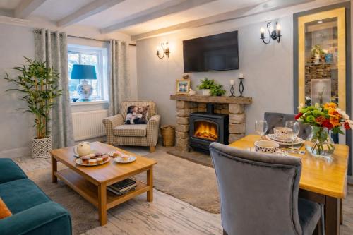 a living room with a table and a fireplace at Charming Shepherd's Cottage, Pets Welcome,Parking in Bridgend