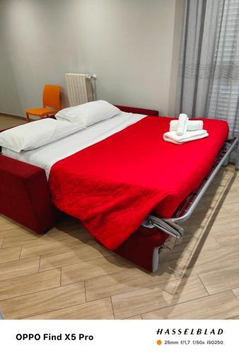 a bed with a red blanket on top of it at A Casa di Maria 2 in Cavallino di Lecce
