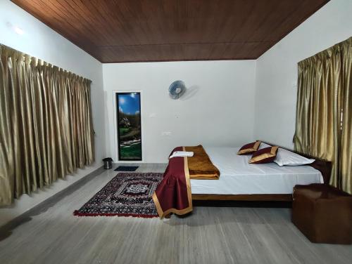 a bedroom with a bed and a large window at Riverwood Cottages in Kallar Vattiyar