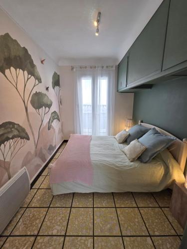 a bedroom with a bed with a painting on the wall at Maison Valras Plage très bon emplacement in Valras-Plage