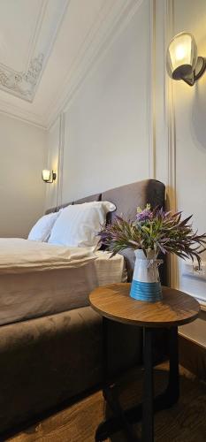 a bedroom with a bed and a table with a vase of flowers at Huma Living in Vlorë