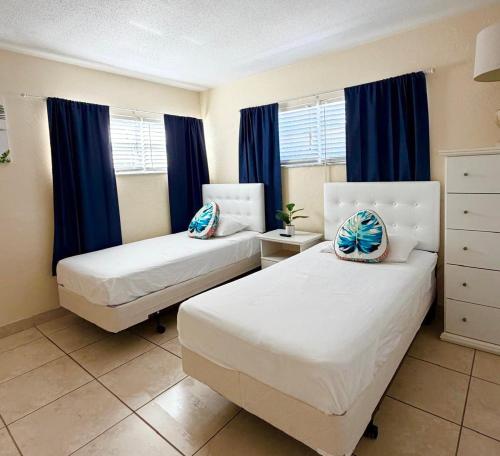 a bedroom with two beds and blue curtains at Ocean 6 - Surfside in Indian Harbour Beach