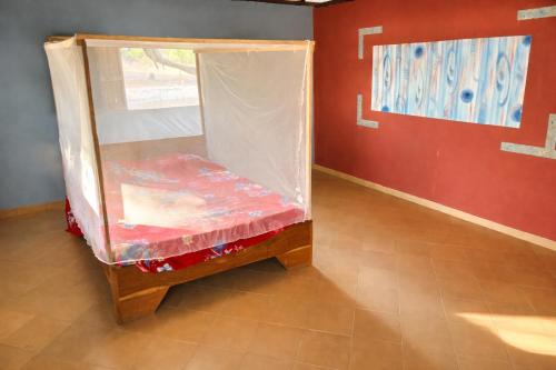 a small bed in a room with a plastic cover at Campement Clair de Lune - Chez Dam et Amcé in Kachiouane