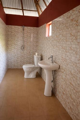 a bathroom with a toilet and a sink at Campement Clair de Lune - Chez Dam et Amcé in Kachiouane