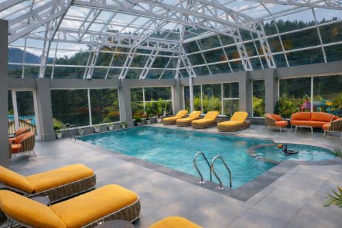 a pool in a building with a glass ceiling at Snow Valley Resorts & Spa Manali in Manāli