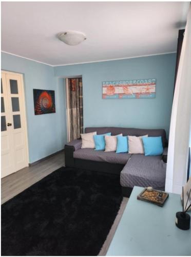 a living room with a couch and blue walls at Casa Rosa da Serra in Sintra