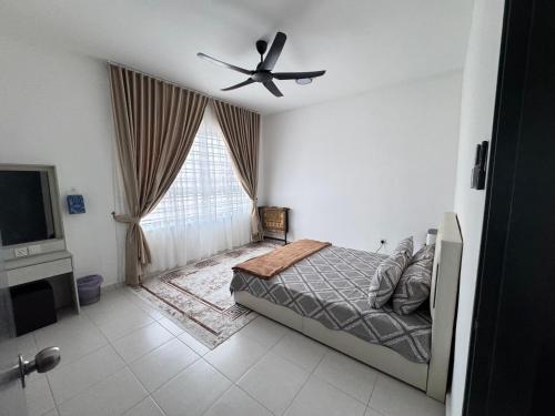 a bedroom with a bed and a ceiling fan at KY Stay D'Serkam in Serkam