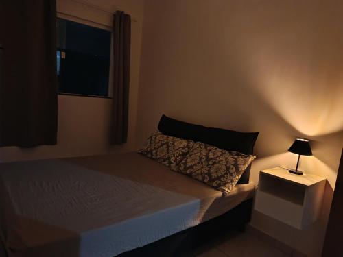 a bedroom with a bed with a lamp on a night stand at Hostel de clecia in Extremóz