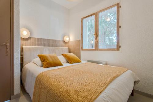 a bedroom with a bed with yellow sheets and a window at T2 Haut de gamme avec jardin privé - 50m du port Miramar in La Londe-les-Maures