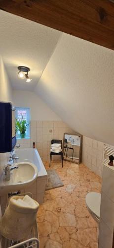 a bathroom with a tub and a sink and a tv at Ferienwohnung Mone - Wohlfühlen am Thüringer Meer in Ziegenrück