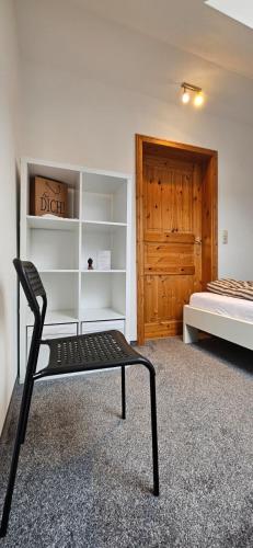 a bedroom with a bed and a chair in a room at Ferienwohnung Mone - Wohlfühlen am Thüringer Meer in Ziegenrück