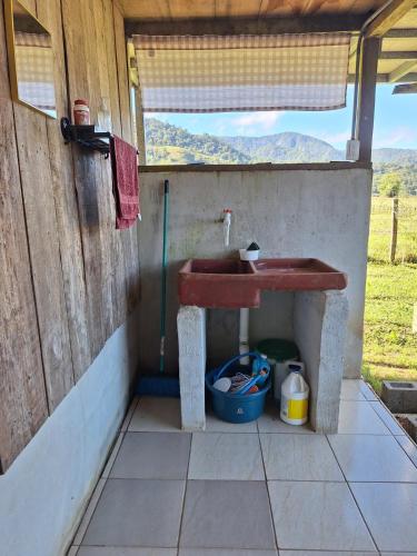 a bathroom with a red sink in a building at Cabaña Cherenga in Sarchí