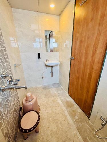 a bathroom with a toilet and a sink at Hotel Aura Inn in Dehu