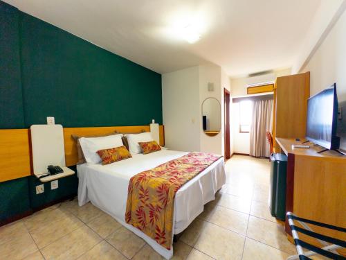 a hotel room with a bed and a television at Portobello Pituba Praia in Salvador