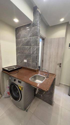 a kitchen with a sink and a washing machine at Egy property in 6th Of October