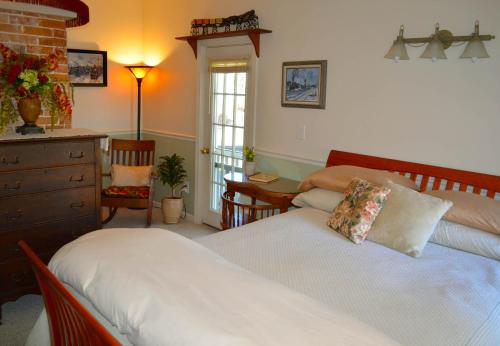 1 dormitorio con 2 camas, mesa y cómoda en Pryor House B&B, en Bath