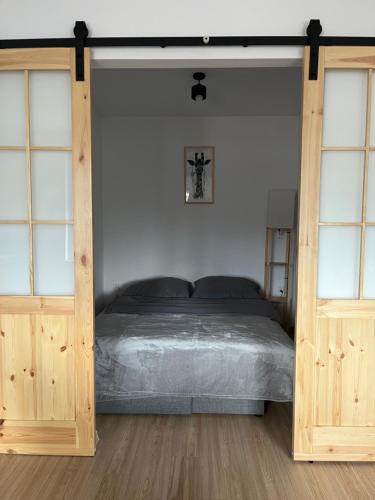 a bedroom with a bed and two wooden doors at Apartament w centrum in Krotoszyn