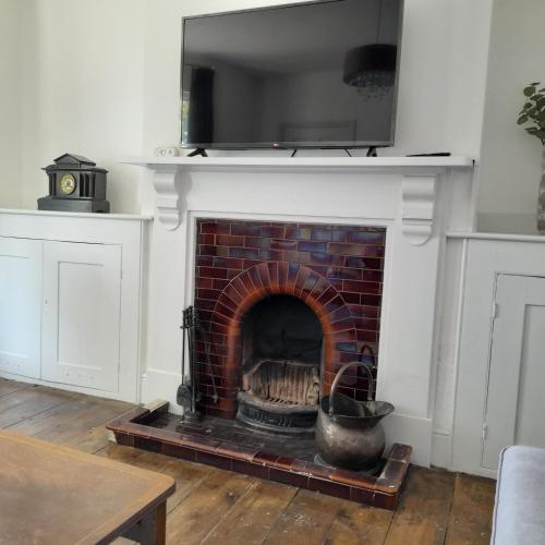 a brick fireplace with a television on top of it at Mill Villa Pakefield in Pakefield
