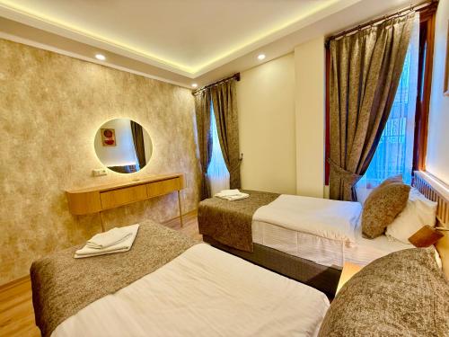 a hotel room with two beds and a mirror at Attalos Villa in Antalya