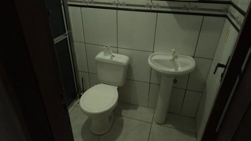a bathroom with a toilet and a sink at Pousada Ventos Bons in Osório