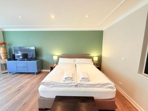 a bedroom with a bed and a tv in it at Amaroo - Serviced Apartment "Andy" in Potsdam