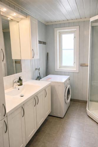 a bathroom with a washing machine and a sink at Nordic Elegance Retreat in Sørvågen