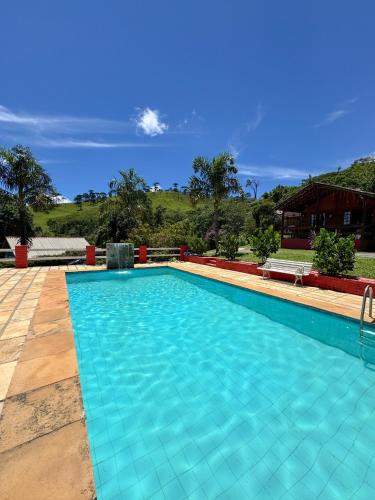 a large swimming pool with blue water at Refúgio Allamanda in Visconde De Maua