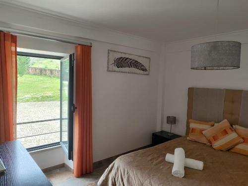a room with a bed with a cross on the floor at Quinta dos Carvalhais - Serra da Estrela in Fornos de Algodres