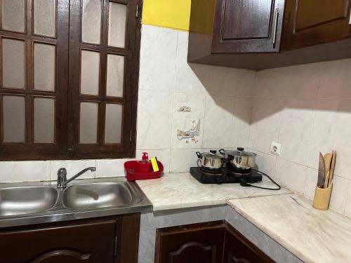 a kitchen counter with two pots on a stove at Quarto- Espaço Casa Mendes in Praia