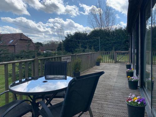 a patio with a table and chairs on a deck at The Old Carthouse in Steyning